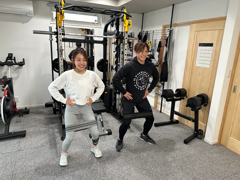 ZKフィットネスの店内で、トレーナーとお客様がスクワットを行っている様子
