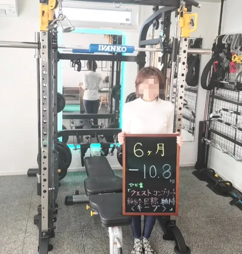 ジムで「6ヶ月 −10.8kg」と書かれた黒板を持つお客様